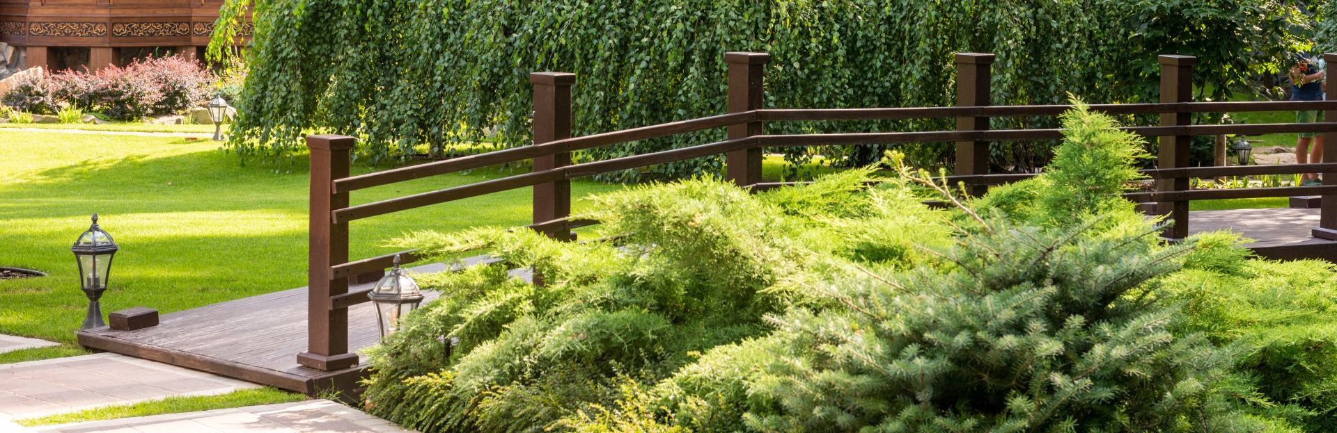 There is a wooden bridge in the middle of a park.