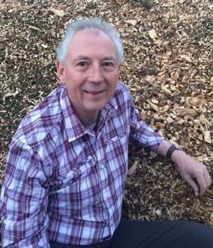 Man sitting outdoors on wood chip ground