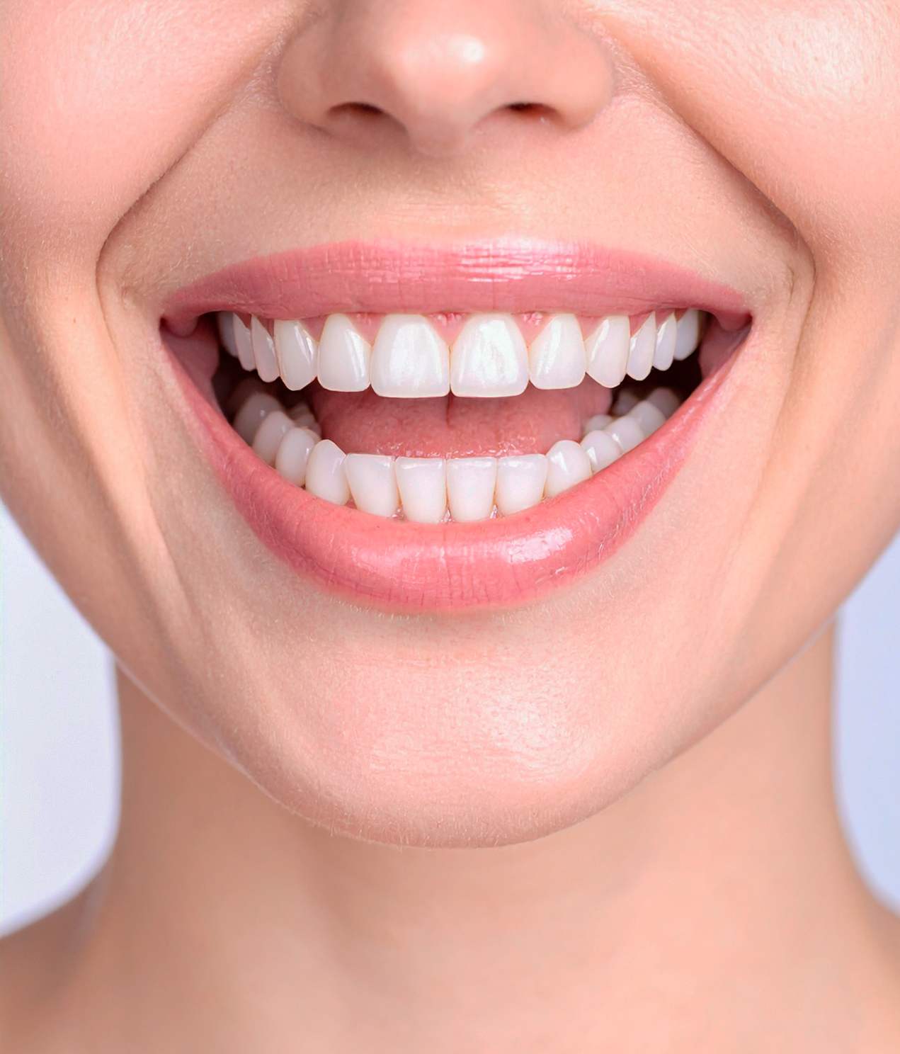 Smiling mouth showing white teeth and pink lips on a neutral background