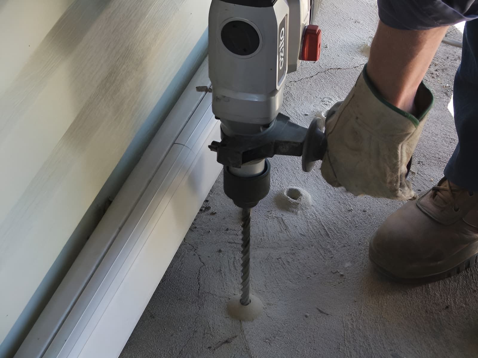 A Person is Using a Makita Drill to Drill a Hole in a Wall — Audy Geiszler Pest Control in Bowen, QLD