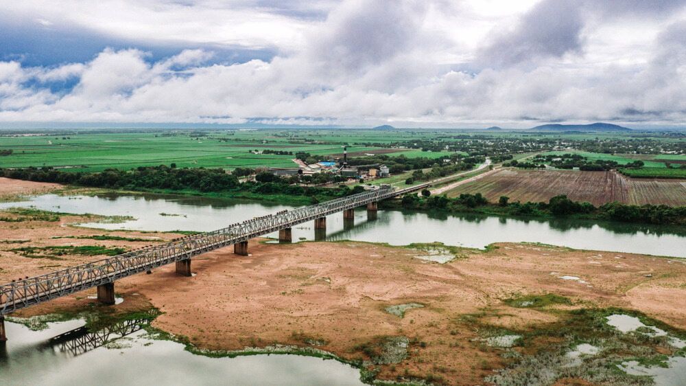An Aerial View of a Bridge Over a River Surrounded by Fields — Audy Geiszler Pest Control in Ayr, QLD
