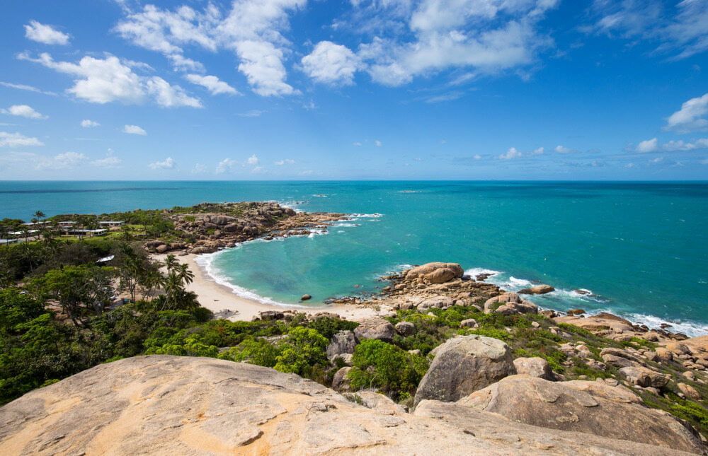 A View of a Beach From a Rocky Cliff Overlooking the Ocean  — Audy Geiszler Pest Control in Bowen, QLD