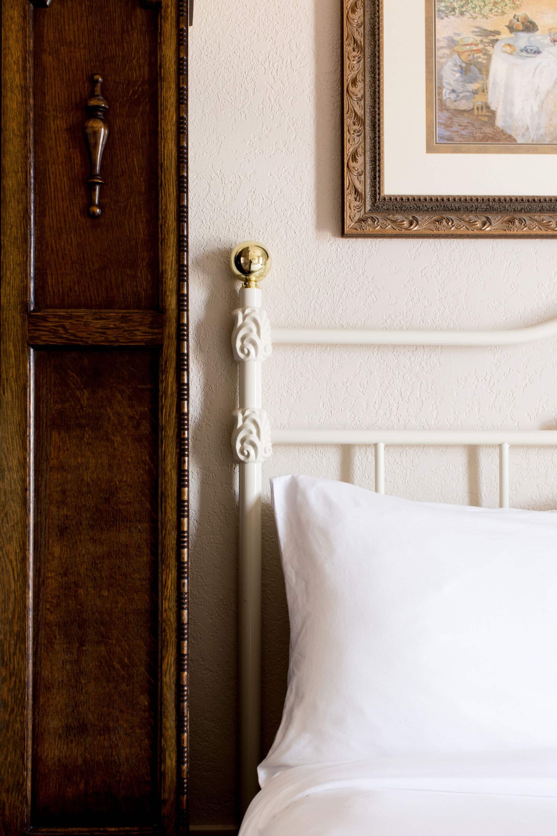 A bed with a picture on the wall above it