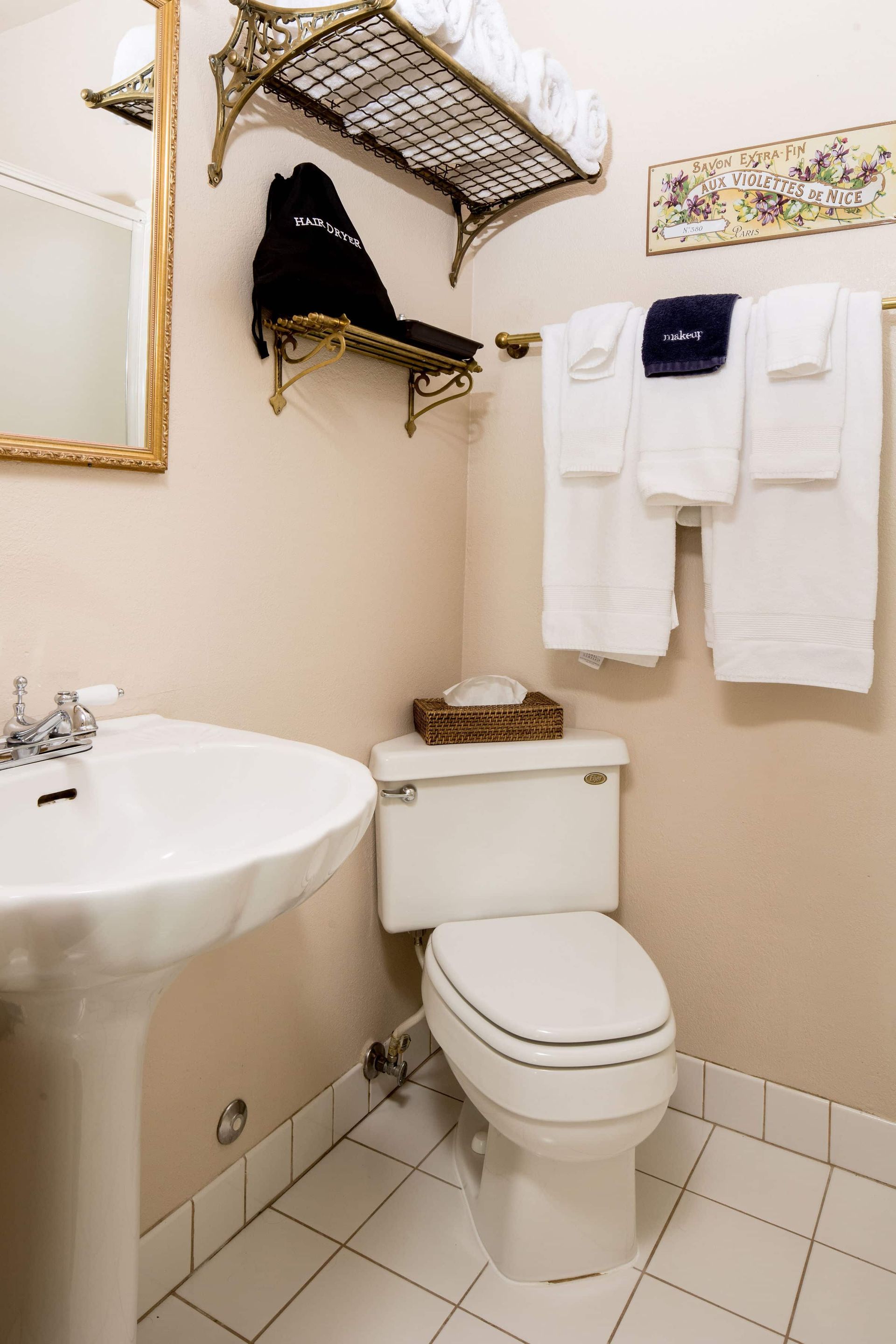A bathroom with a toilet , sink and mirror.