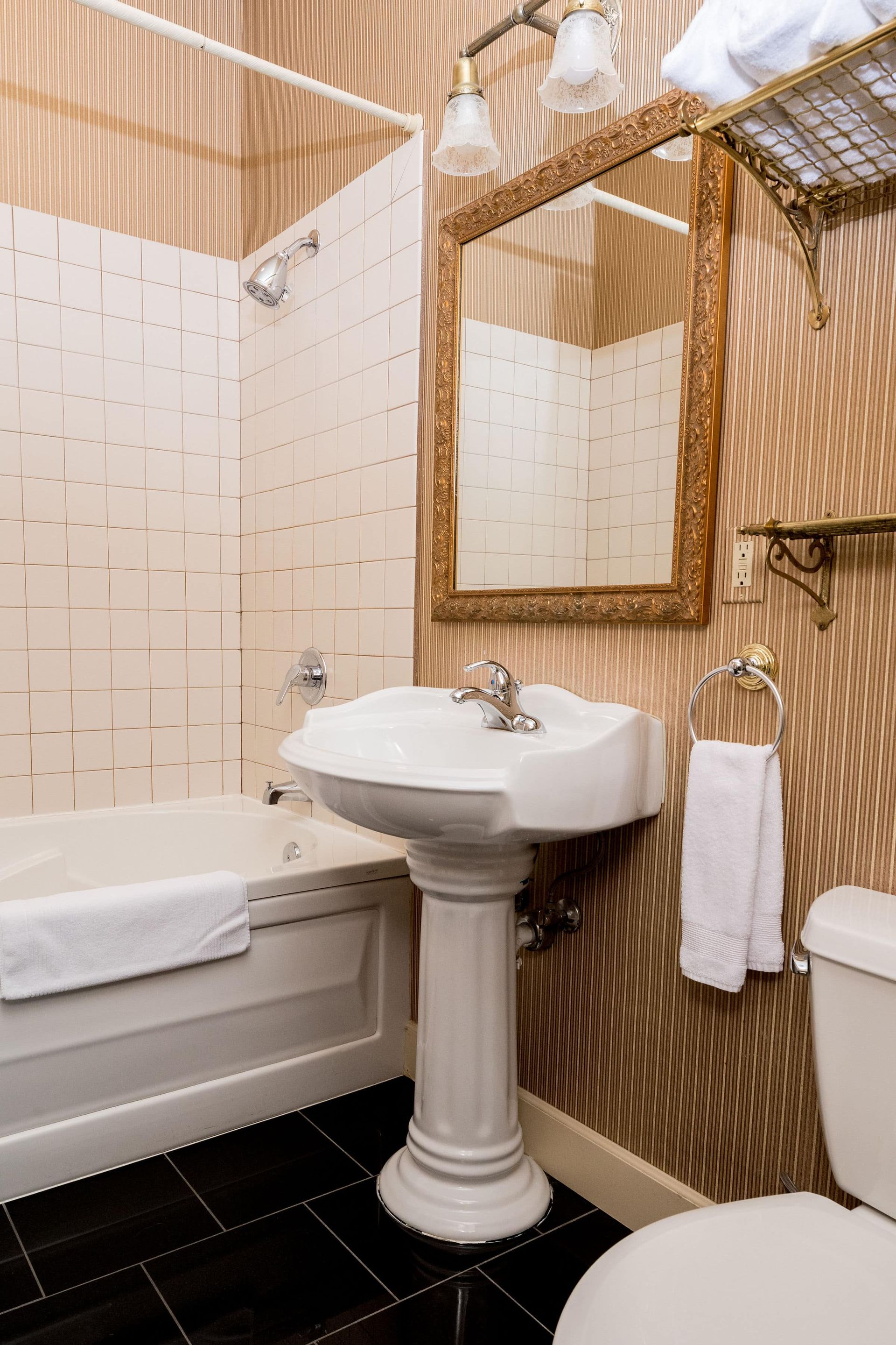 A bathroom with a sink , toilet , bathtub and mirror.