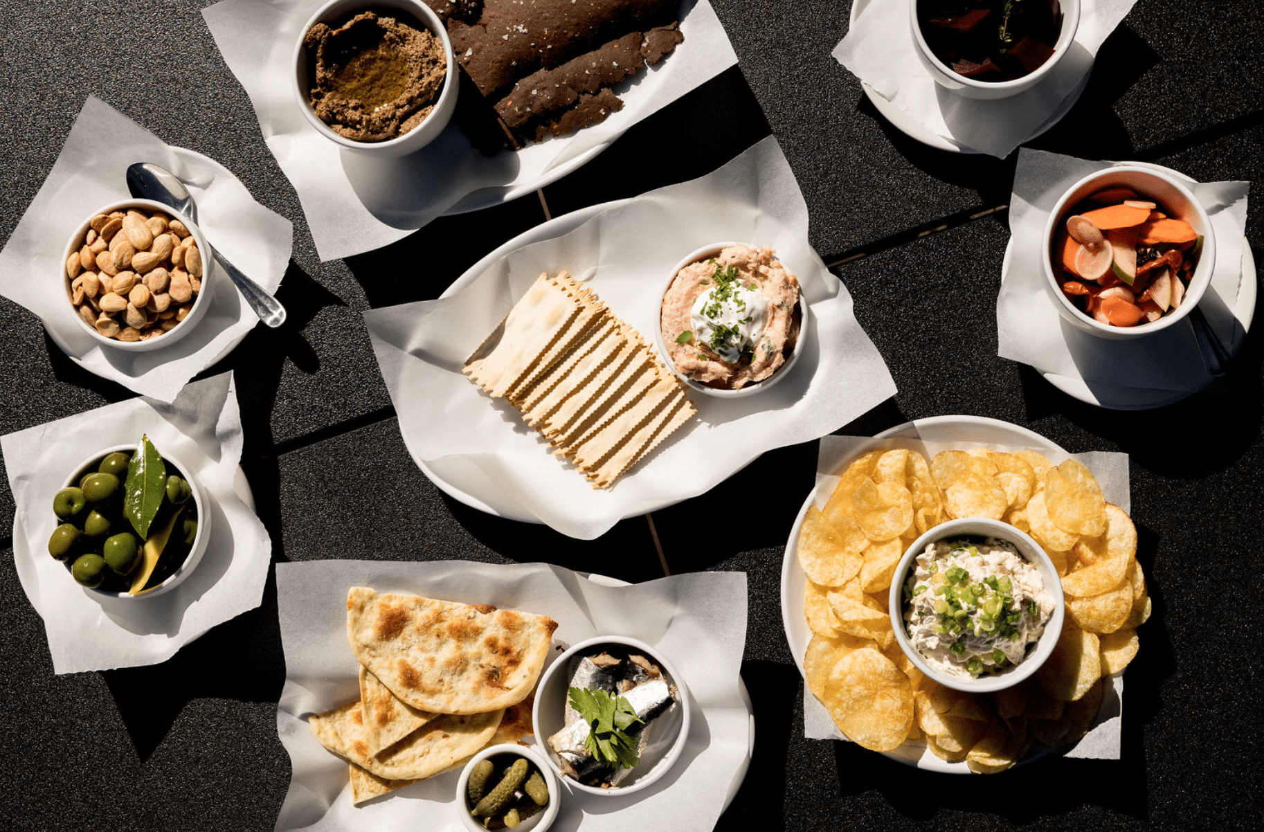 A table topped with plates of food and bowls of dips.