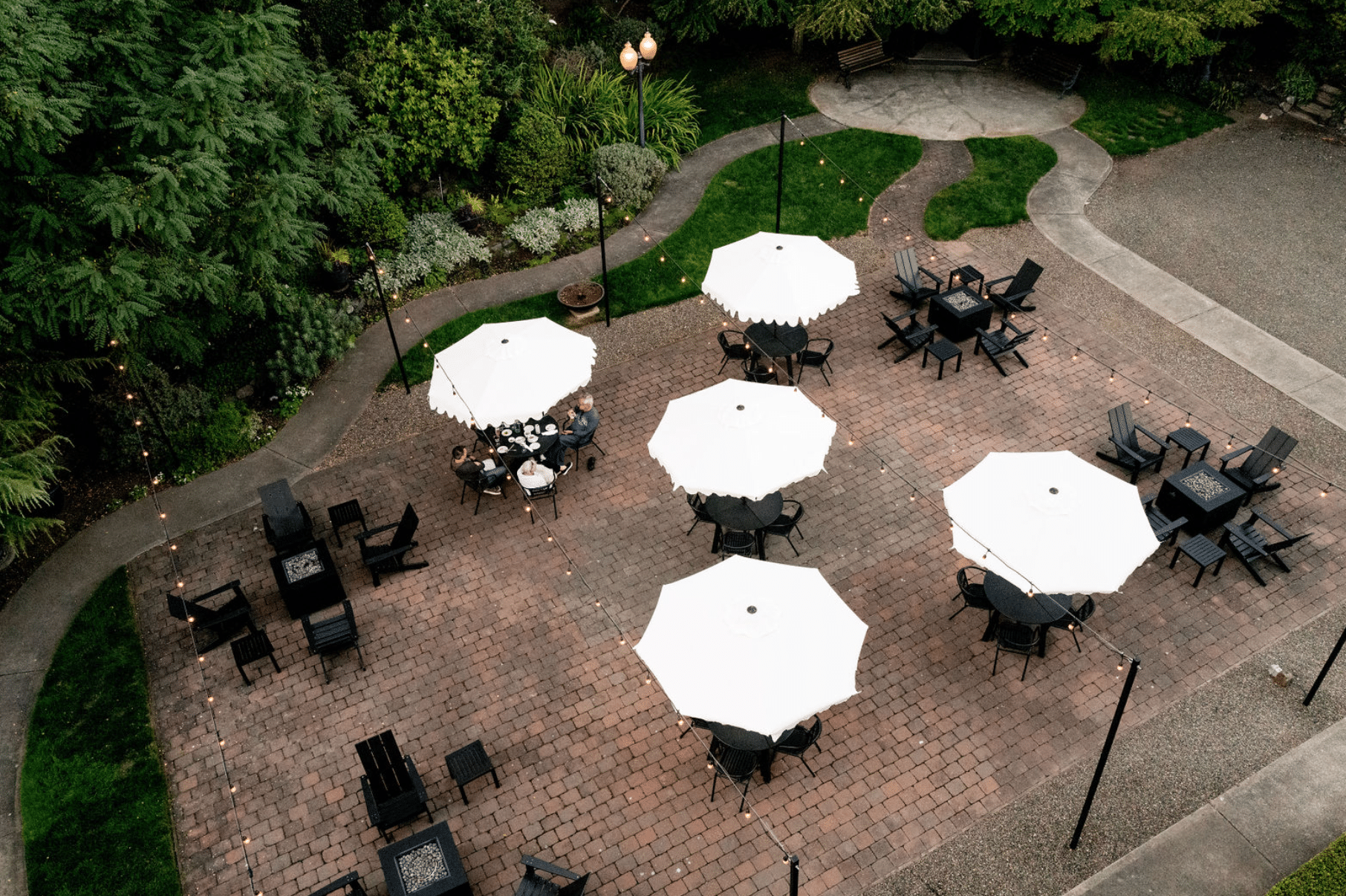 An aerial view of a patio with tables and chairs and umbrellas.