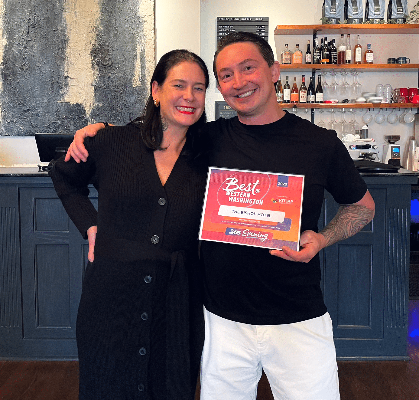 A man and a woman are posing for a picture and the man is holding a certificate that says best place to eat