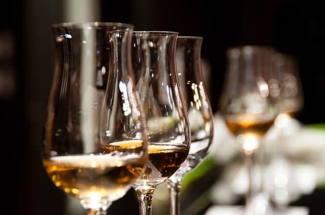 A row of wine glasses filled with wine on a table.