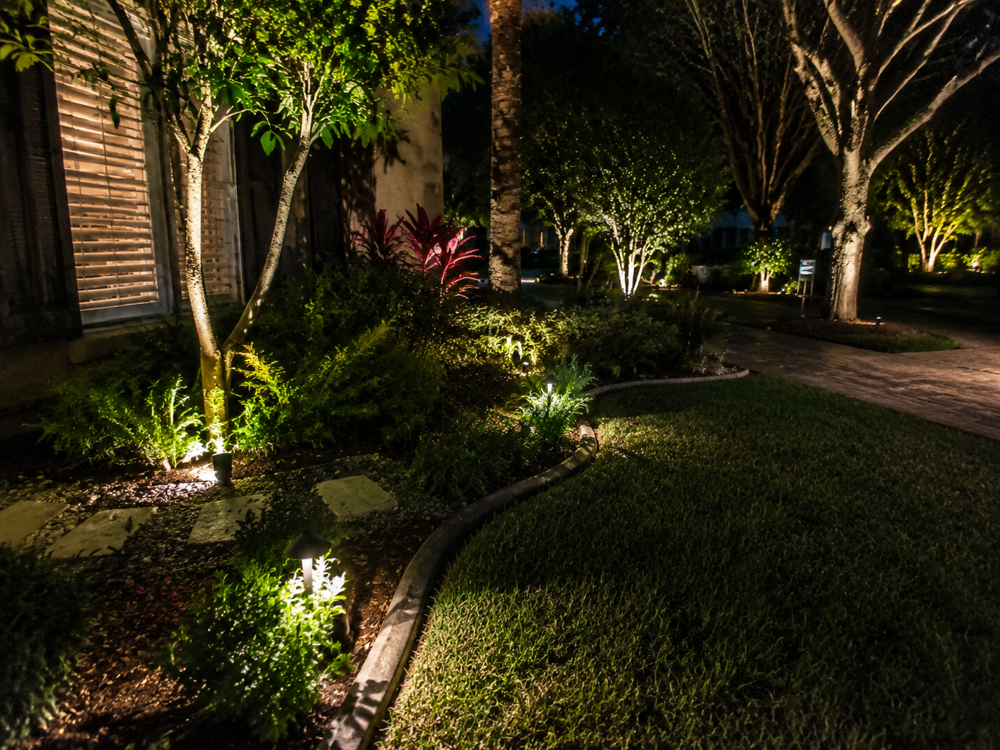 A house lavishly decorated with warm white Christmas lights and garlands at night