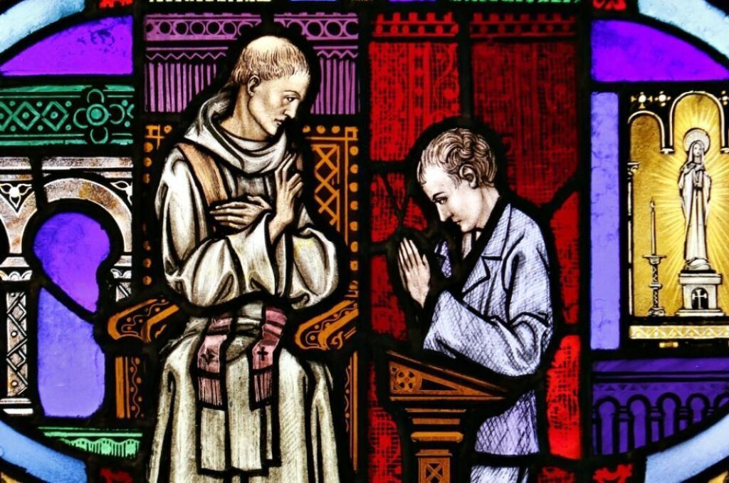 Stained glass art depicting a monk seated and a kneeling figure praying. Stained glass art depicting a monk seated and a kneeling figure praying.