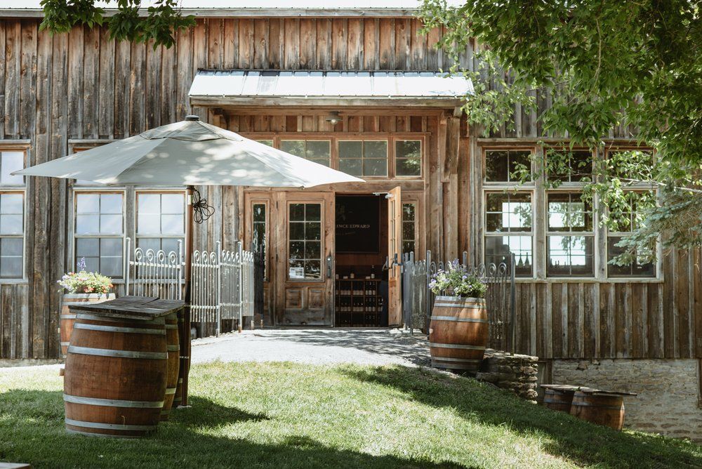 Walkway lined with barrels leading up to rustic winery