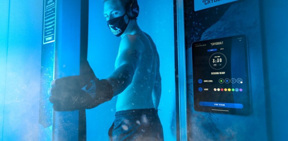 Man in cryotherapy chamber wearing mask and gloves, at BodyBalance Health & Wellness Center.