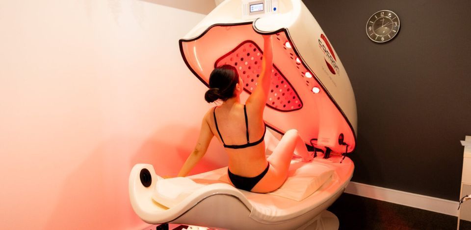 Woman in swimsuit inside an infrared sauna pod at  BodyBalance Health & Wellness Center in Horsham, PA.