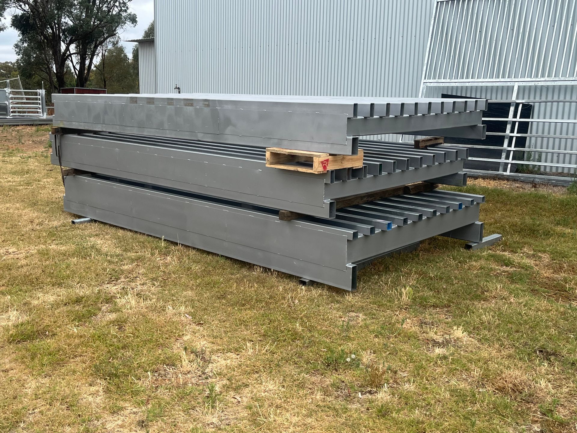 A Metal Platform is Sitting in the Middle of a Dirt Field in Front of a Building — Ballimore Welding in Ballimore, NSW