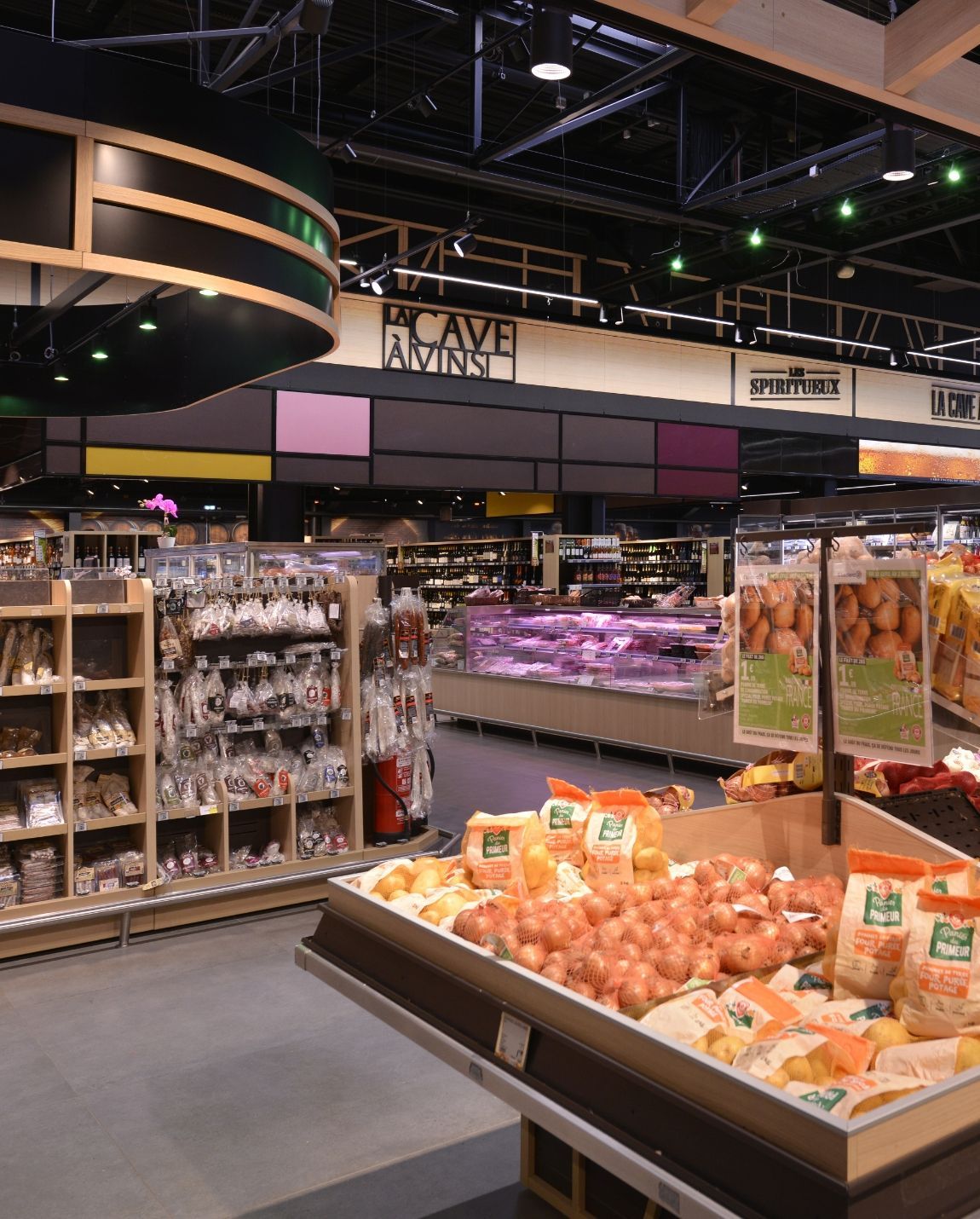 Rayons de fruits et légumes et allées d'épicerie de supermarché avec étagères, vitrines réfrigérées et éclairage zénithal vif