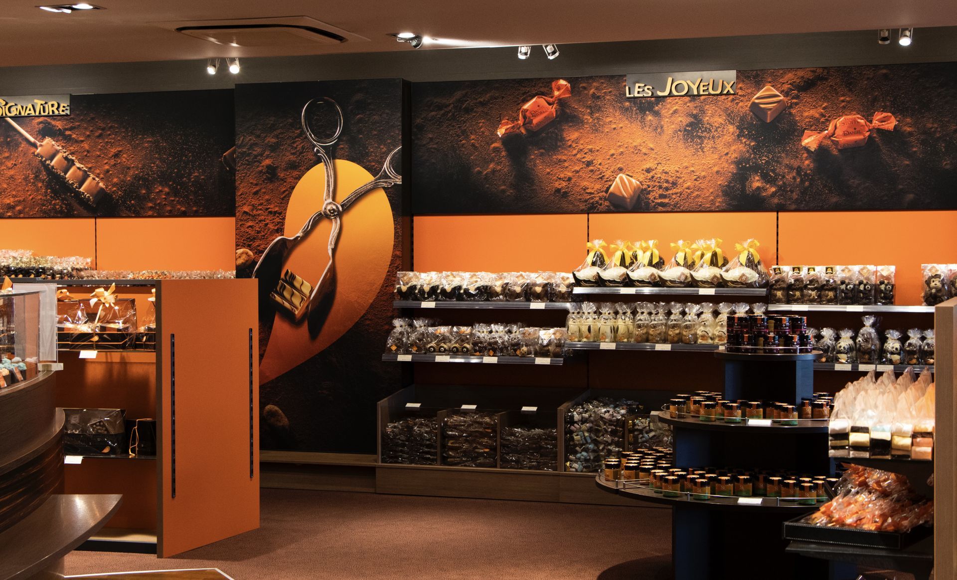Interior of a shop with shelves of jars and bottles, orange walls, and decorative murals.