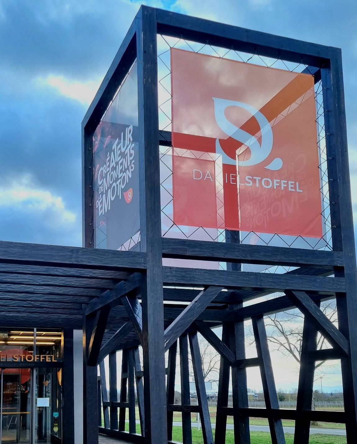 Black wooden structure with a red and orange sign that says 