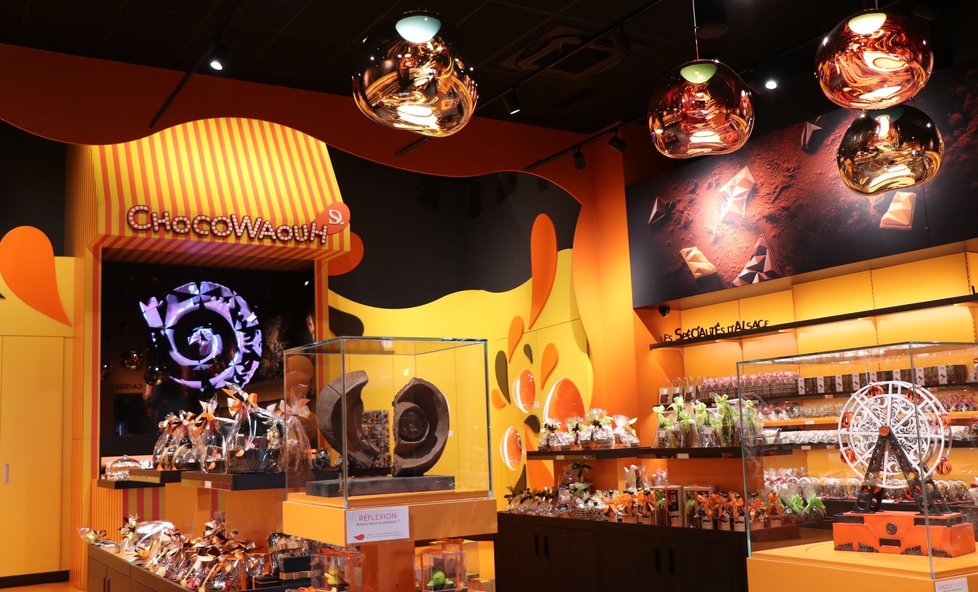 Inside a colorful store, merchandise displayed on shelves, under decorative lighting.