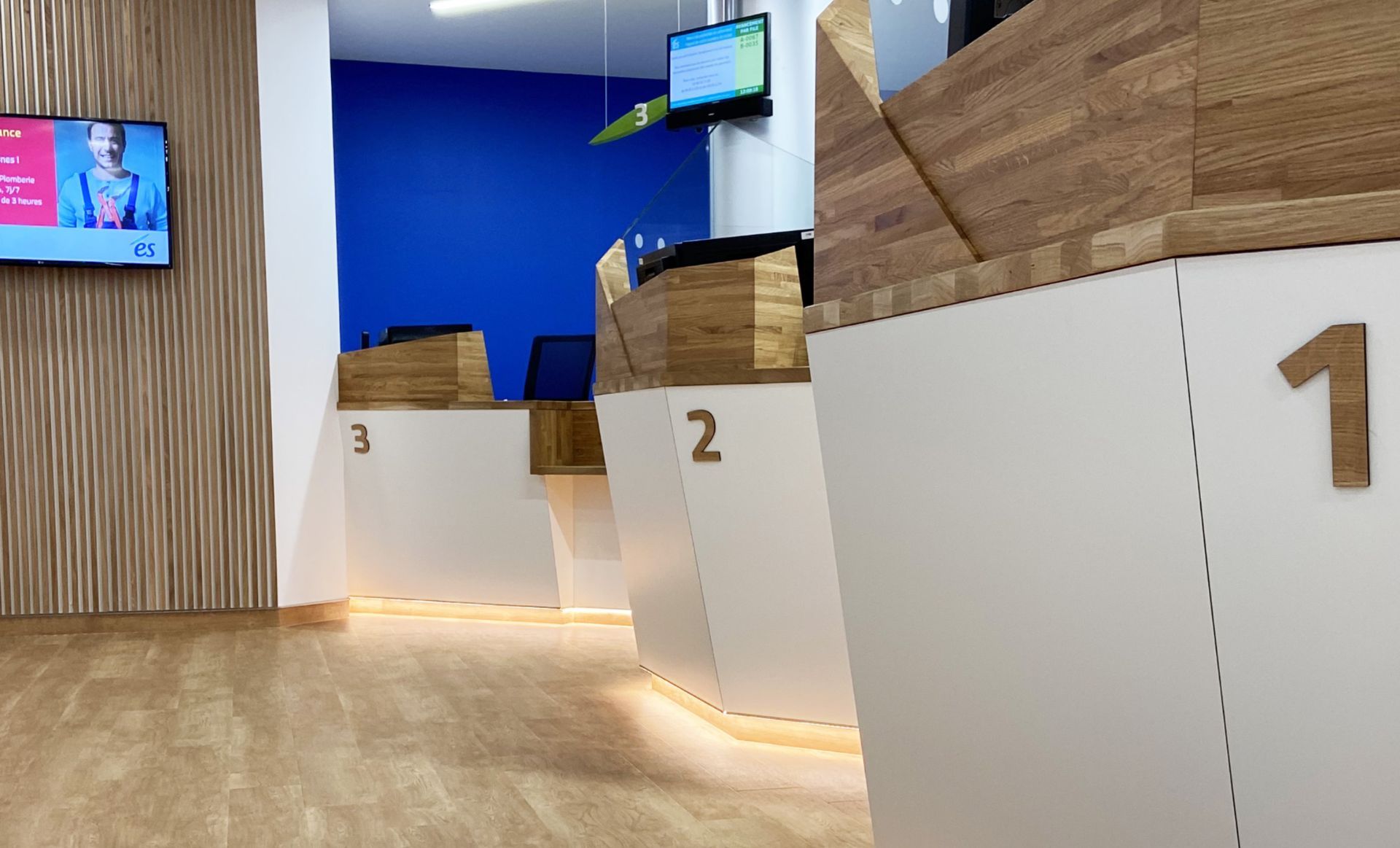 Check-in counters numbered 1, 2, and 3 in a brightly lit, modern office space.
