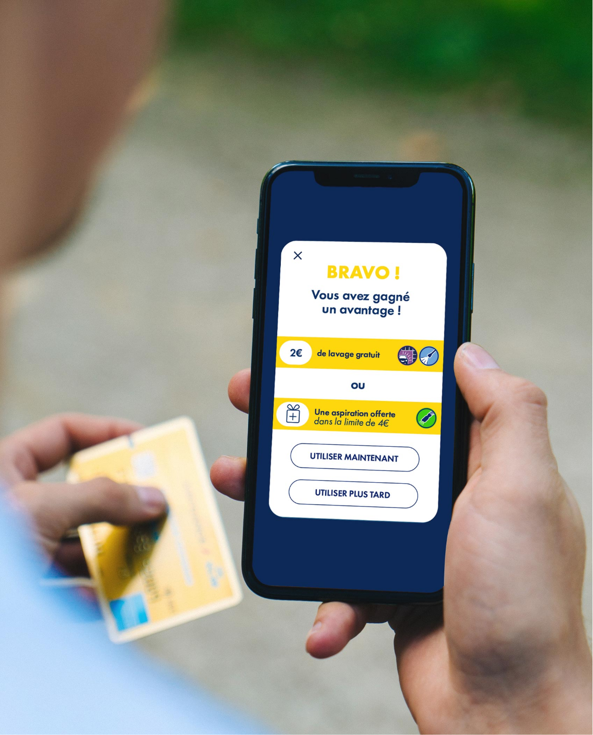 Person holding a phone displaying a digital card and a credit card.