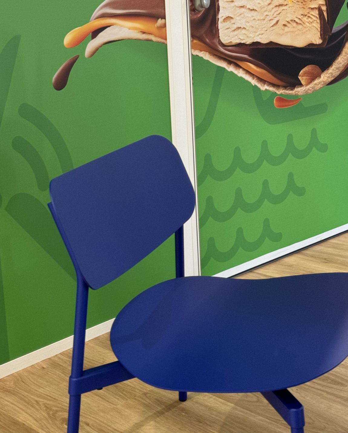 Blue chair in front of a green wall with ice cream graphic.