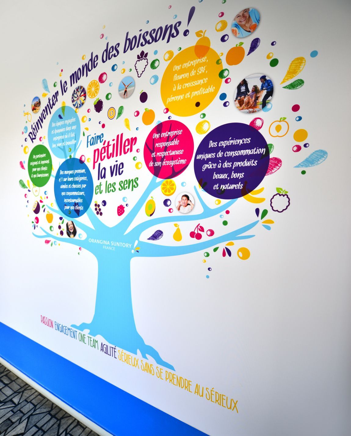 Colorful tree mural on a white wall with text bubbles, promoting drinks and 
