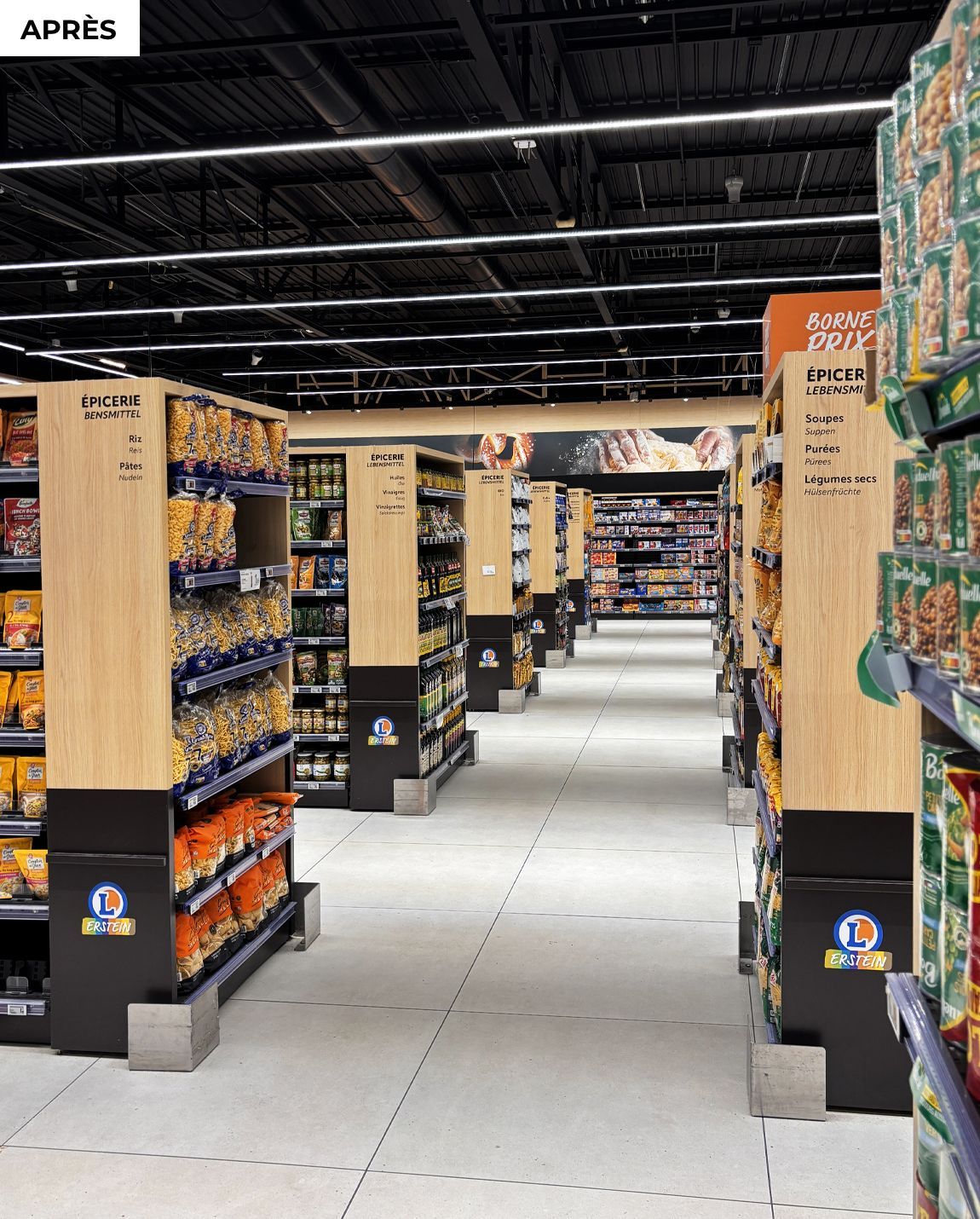 APRES  allée Hypermarché avec des étagères remplies de produits emballés colorés et un sol lumineux et ouvert.