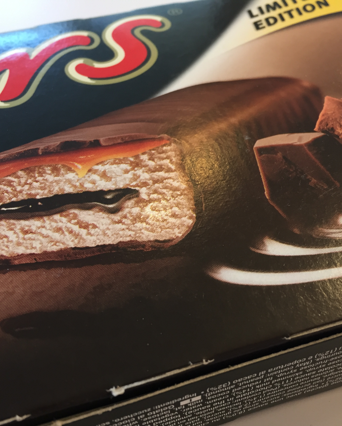 Close-up of a Mars ice cream bar, cut to show layers of chocolate, caramel, and vanilla ice cream.