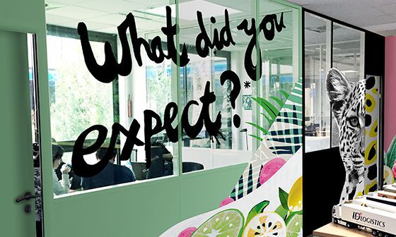 Office interior with glass walls, graffiti-style text