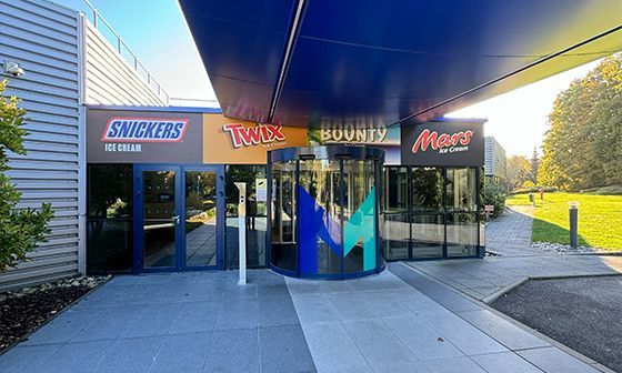 Entrance to Mars candy factory with rotating door, labeled with Snickers, Twix, Bounty, and Mars logos.