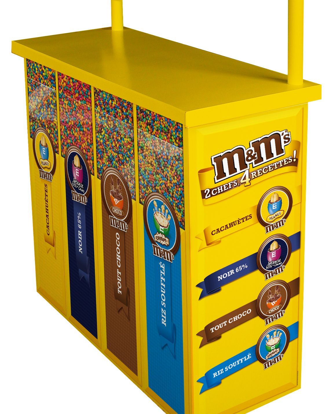 Yellow M&M's candy dispenser with various colored candy sections and a sign with the M&M's logo.