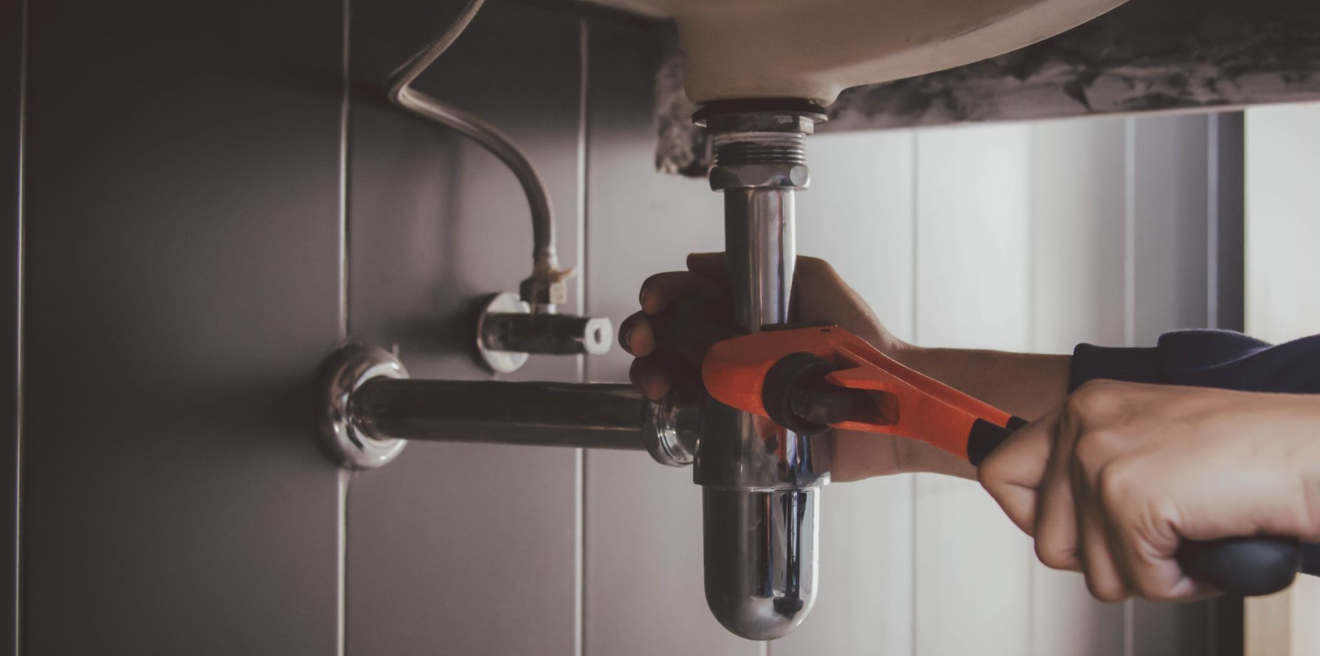 A person is cleaning a water filter next to a water tank.