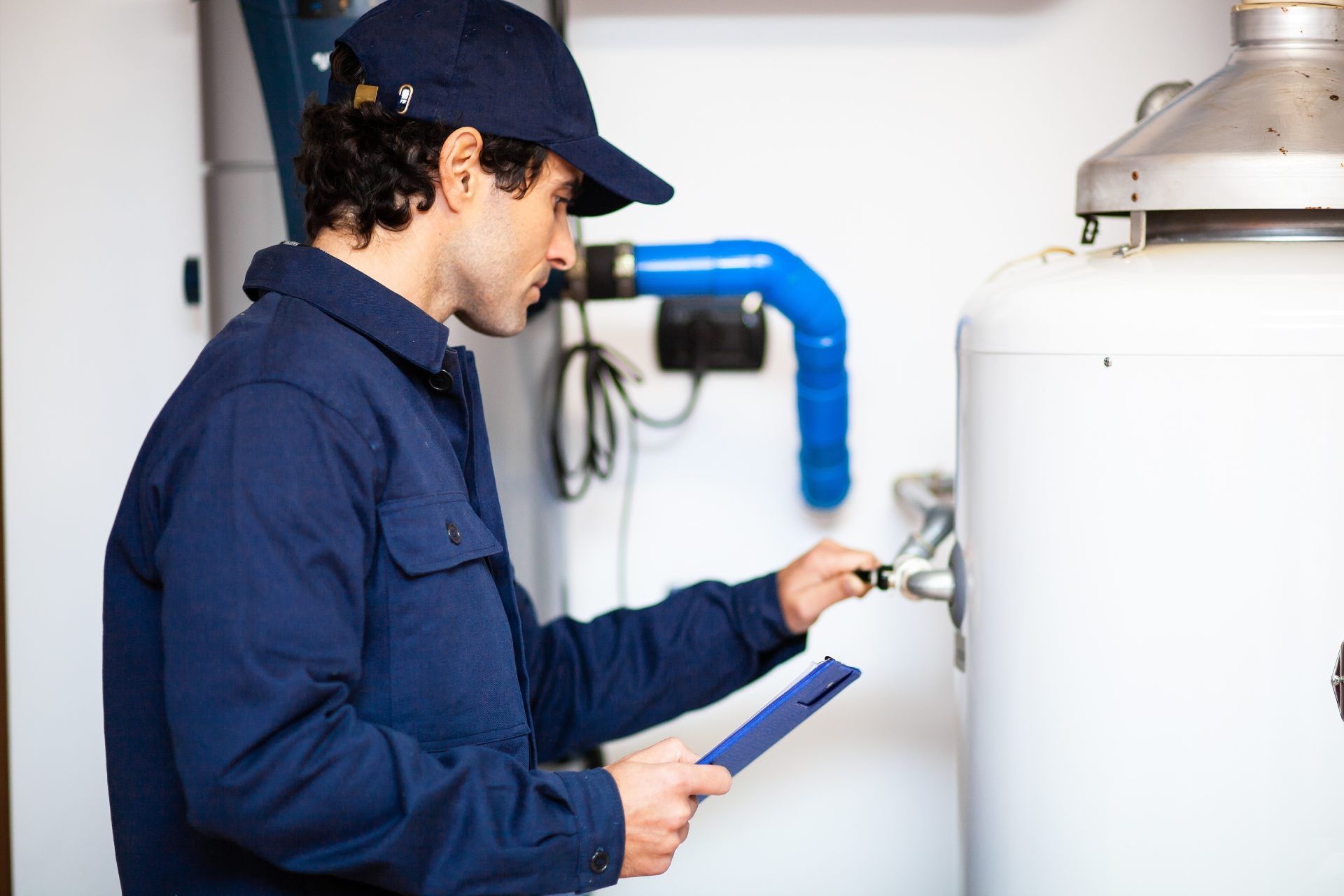 A person is cleaning a water filter next to a water tank.