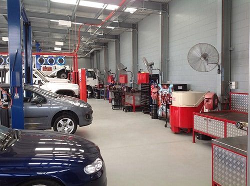A Car Is On A Lift In A Garage — MB Automotive In Garbutt, QLD