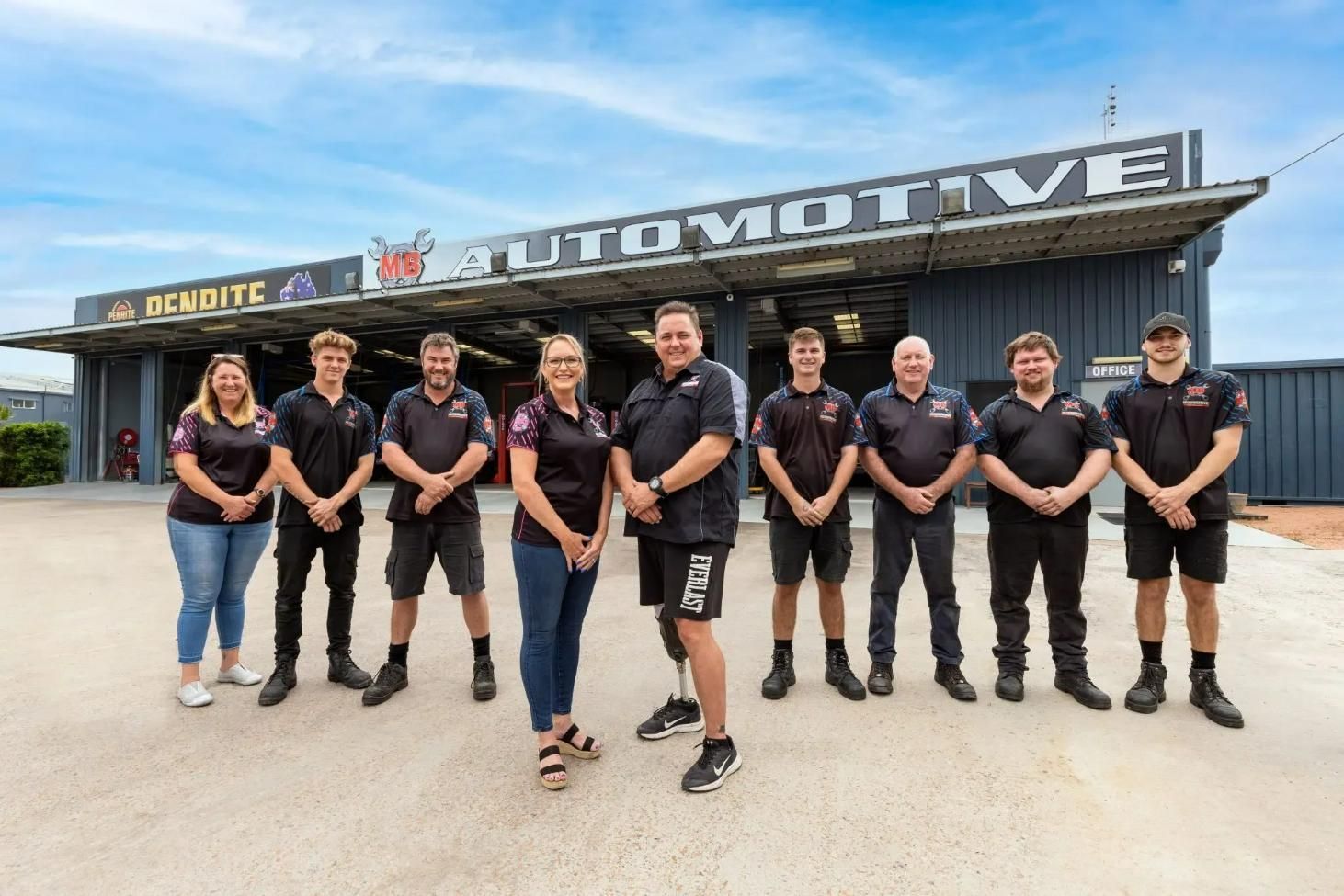 A Group Of People Standing In Front Of An Automotive Shop — MB Automotive In Garbutt, QLD