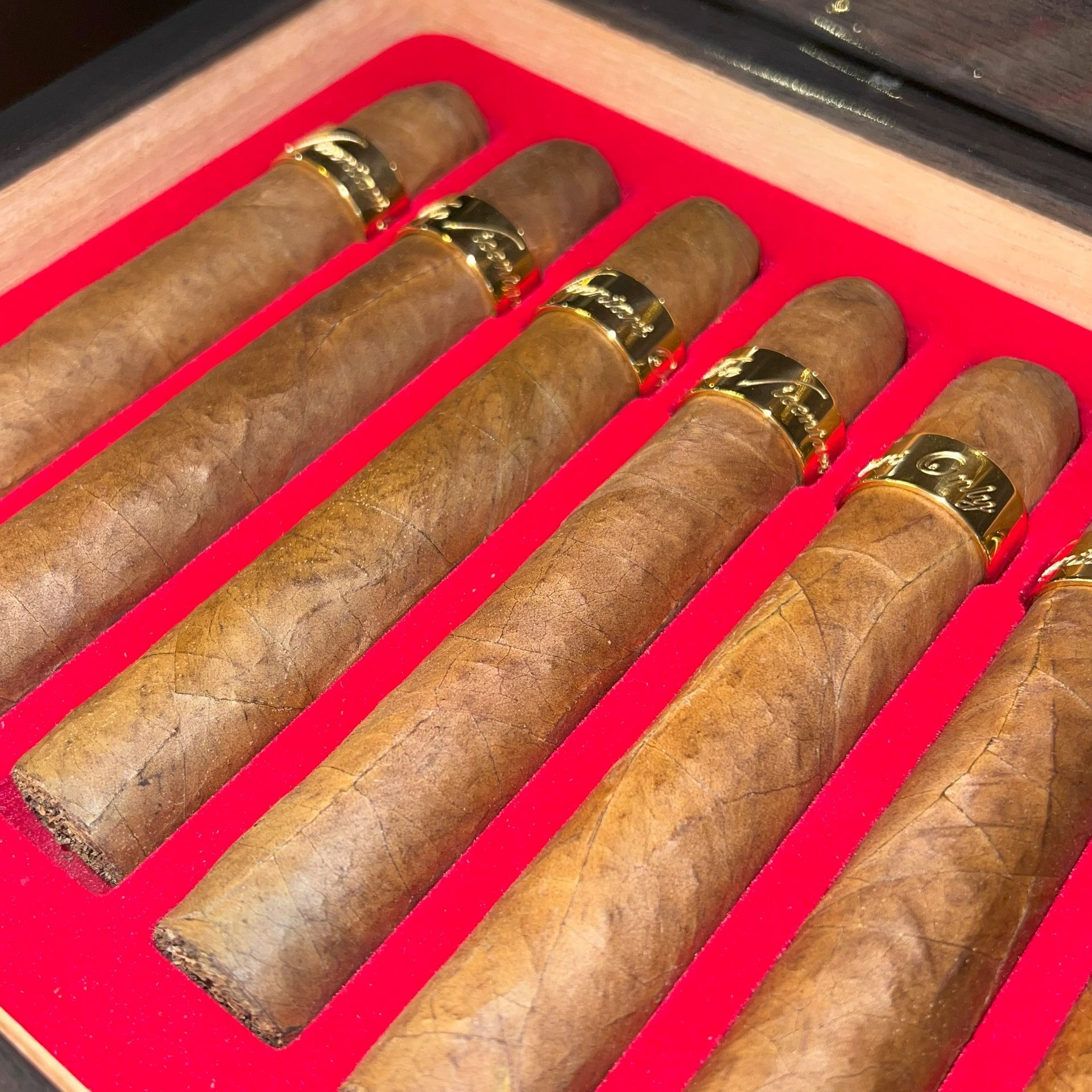 Five cigars in a red-lined wooden display box