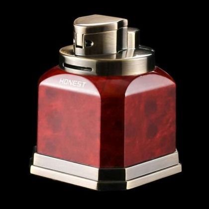 Red and silver HONEST perfume bottle with a metallic cap on a black background