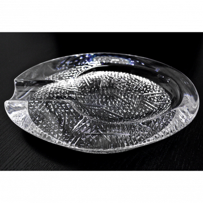 Clear glass leaf-shaped dish on a black background