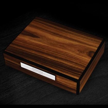 Wood-grain wooden presentation box with a white label on a dark surface