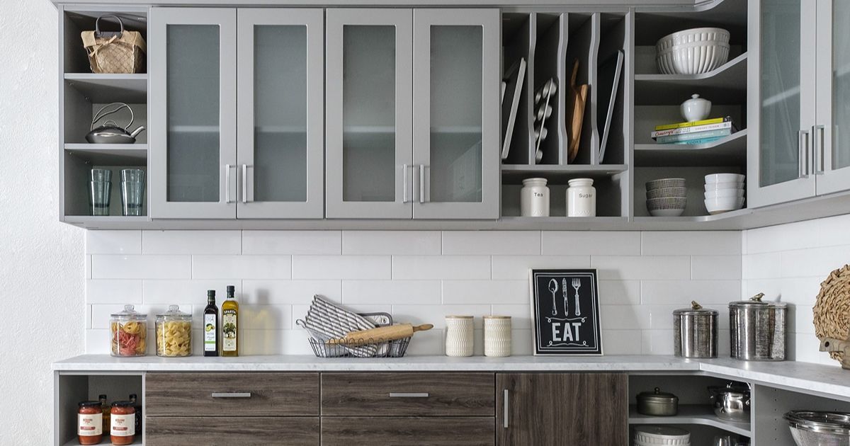 Gray and brown modern kitchen with upper cabinets, lower cabinets, and white backsplash.