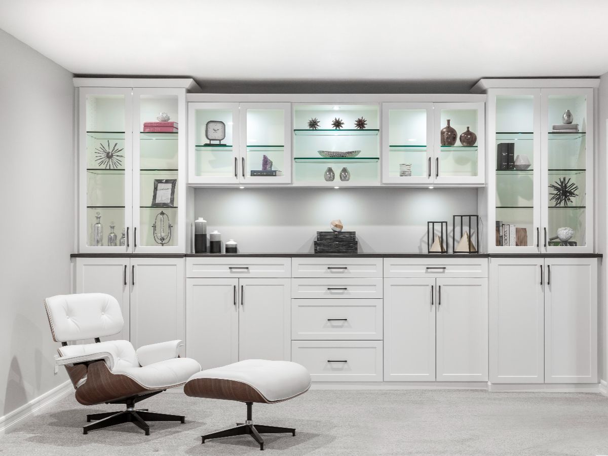 A well-organized walk-in closet with teal cabinetry and white shelving. Clothes hang, and decorative items are on display.