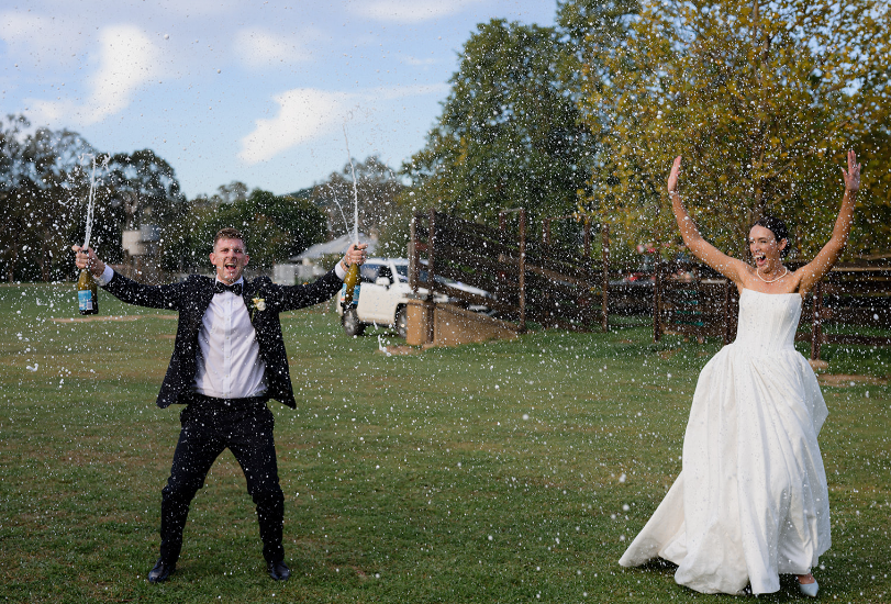 Champagne spray in celebration with the bride and groom