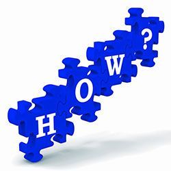 Blue puzzle pieces spelling “HOW?” in a diagonal arrangement on a white background in Columbus Ohio