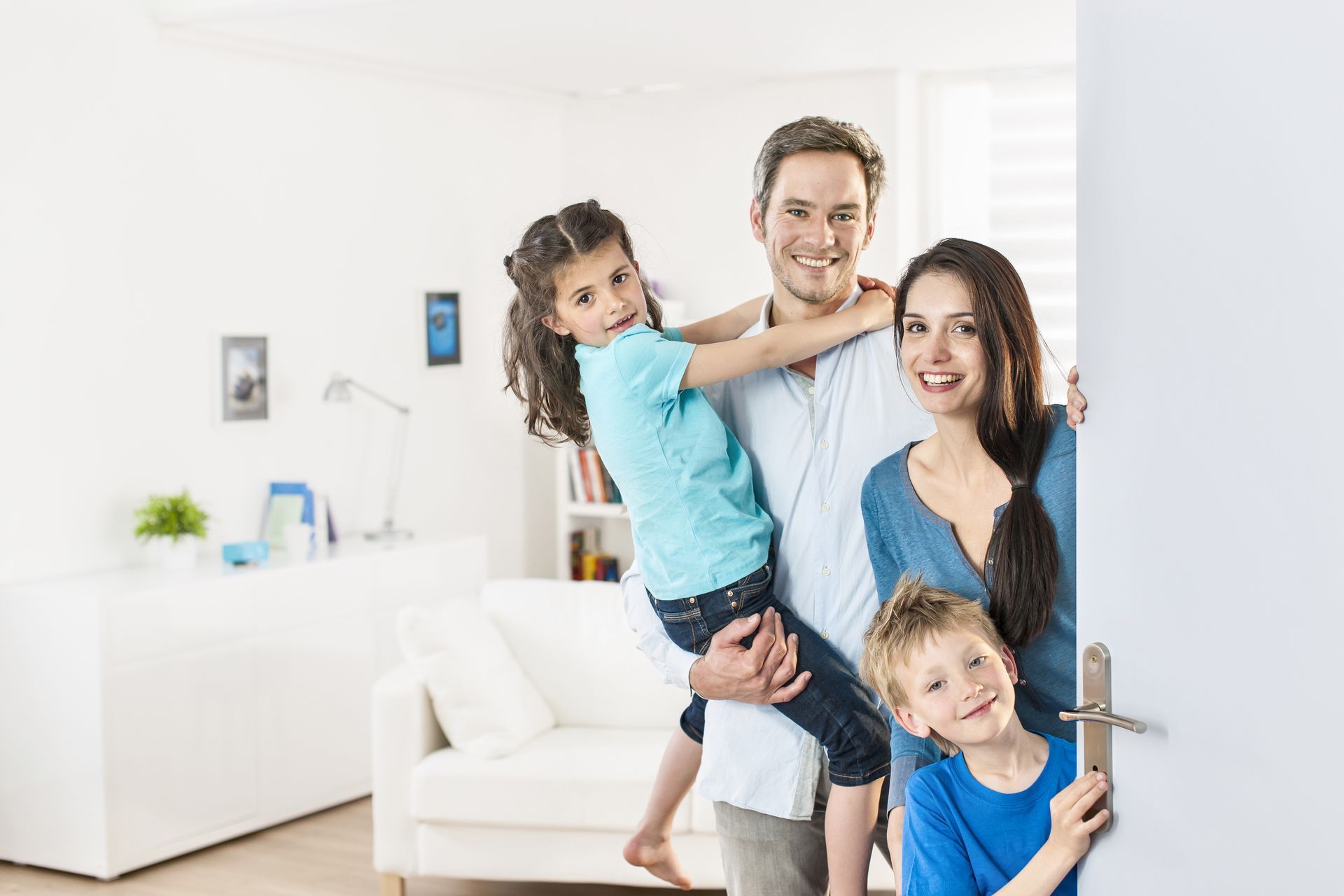 Smiling family standing at a front door in a bright living room in Columbus Ohio