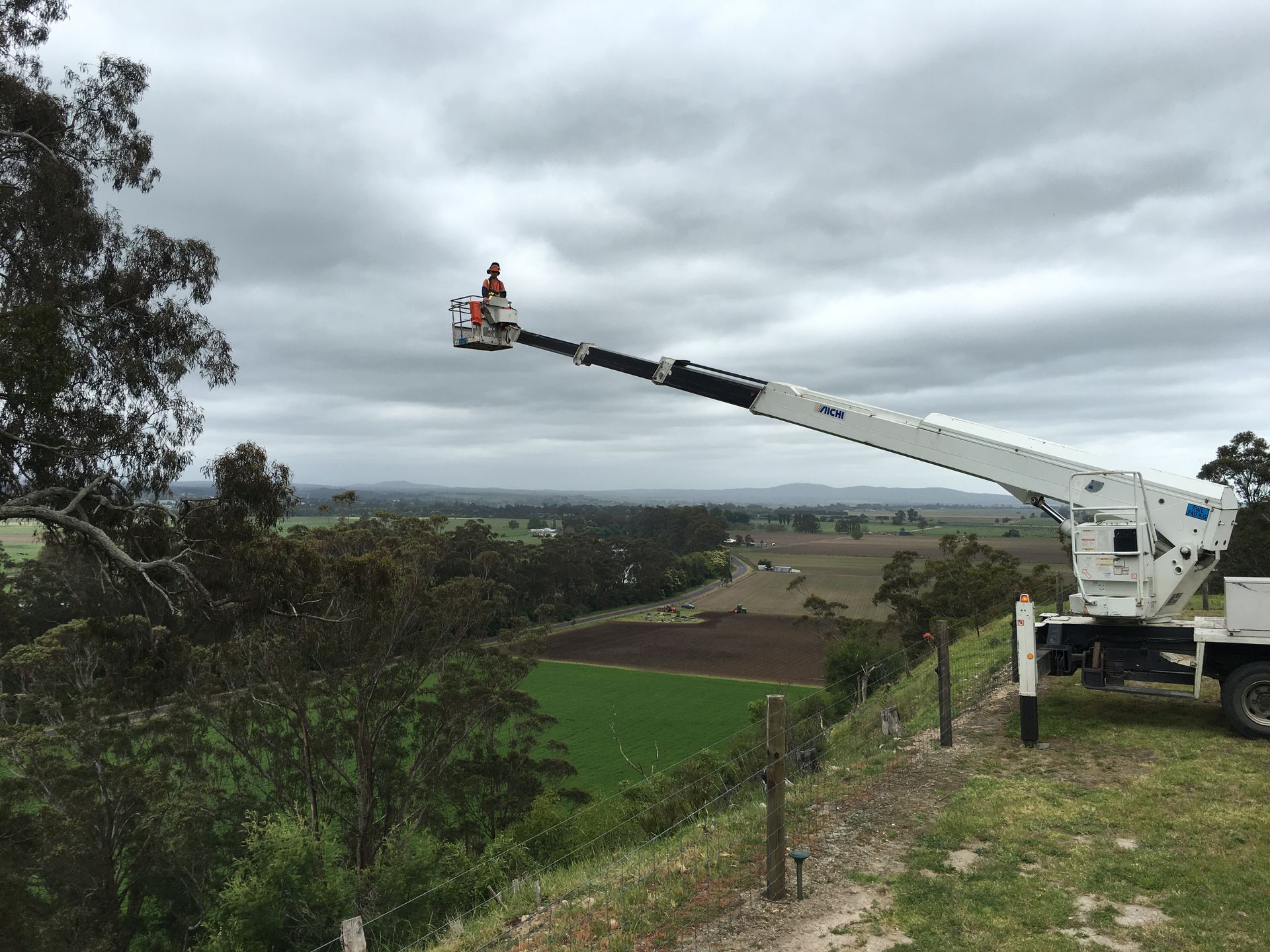 Person In Boom Lift High Above Landscape.
