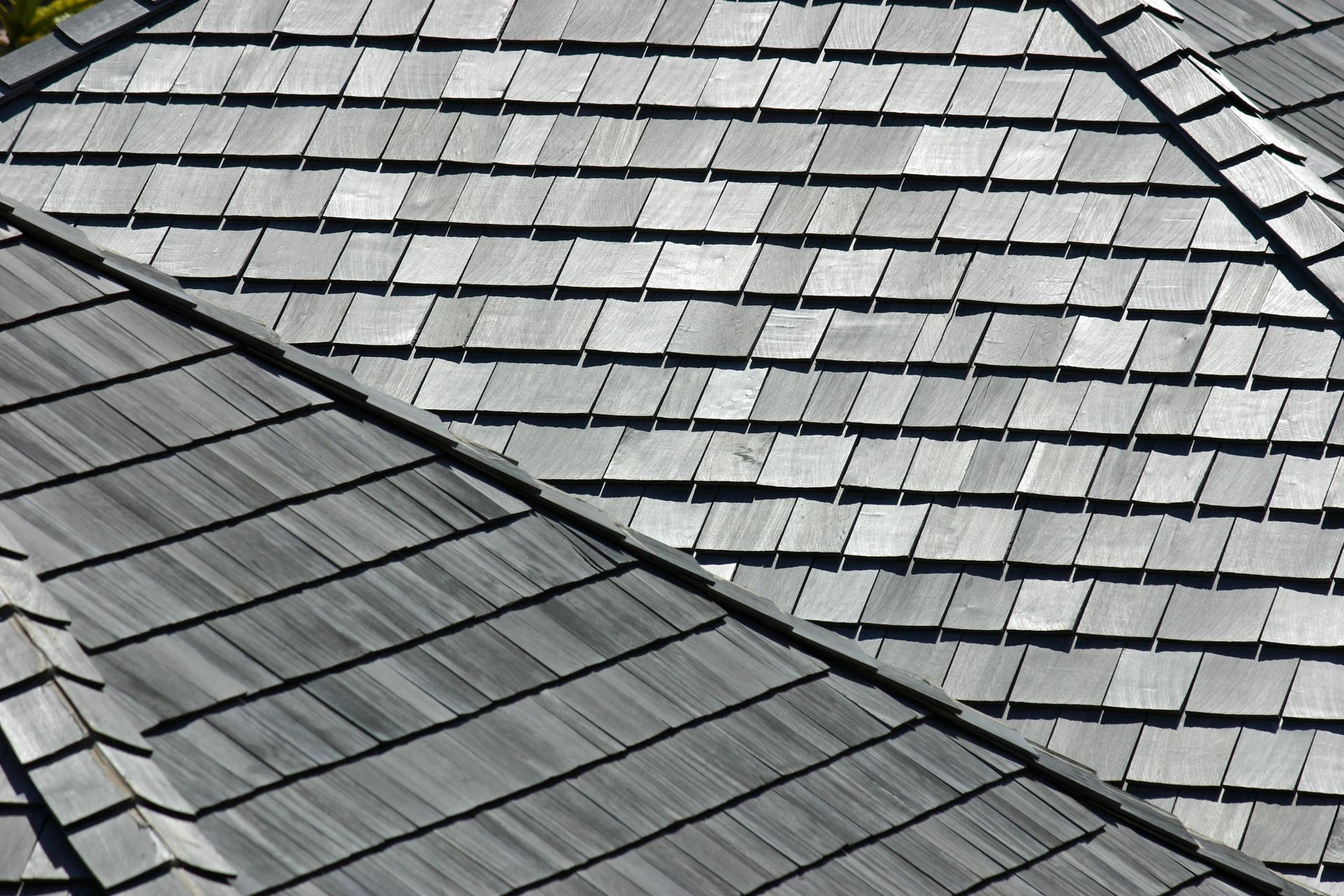Gray shingled rooftops with intersecting rooflines viewed from above