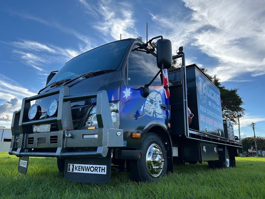 A Large Truck is Parked in a Grassy Field — Trucks On The Run Pty Ltd in Harristown, QLD