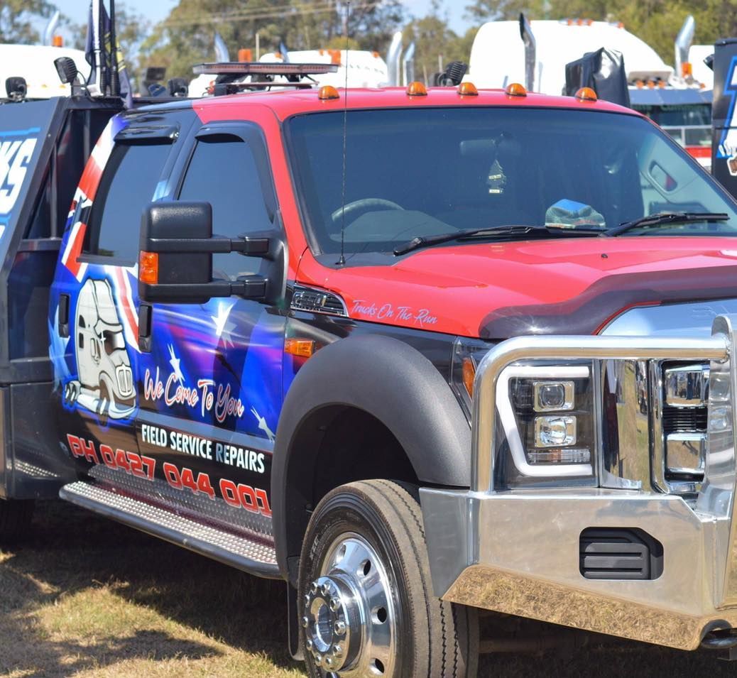 A Red Truck With a Blue Sticker on the Side — Trucks On The Run Pty Ltd in Crows Nest, QLD