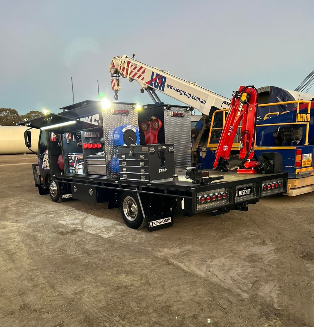 A Truck With a Crane on the Back is Parked Next to Another Truck — Trucks On The Run Pty Ltd in Kingsthorpe, QLD